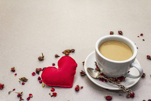 Dobré ráno. Šálek kávy, růžové poupata a okvětní lístky, červené plstěné srdce. Romantická snídaně, Valentýn. Kamenné betonové pozadí - Fotografie, Obrázek