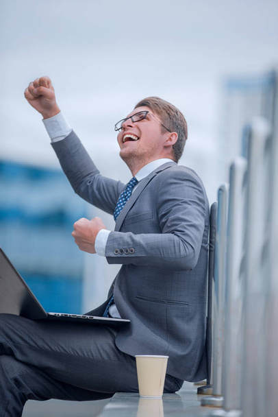 happy business man with laptop on background of office building. - Zdjęcie, obraz