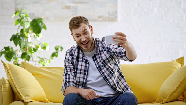hombre alegre tomando selfie en teléfono inteligente y mostrando el pulgar hacia arriba
 - Metraje, vídeo