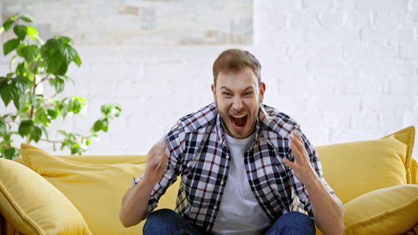 šťastný hráč ukazuje vítězný gesto při držení smartphone - Záběry, video