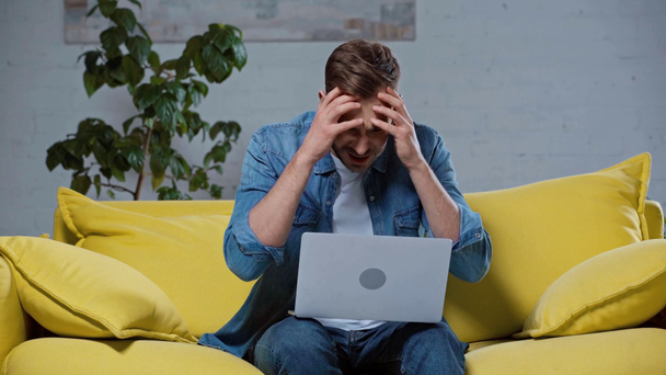 naštvaný muž dělat online sázky na notebook doma - Záběry, video