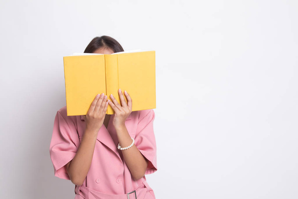 Young Asian woman with a book cover her face. - Foto, afbeelding