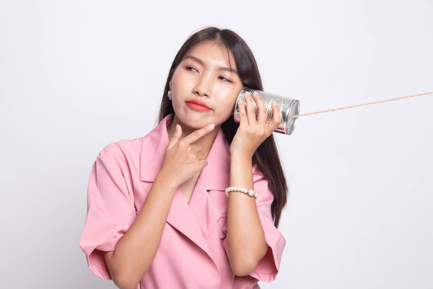 Young Asian woman hearing with tin can phone and thinking. - Valokuva, kuva