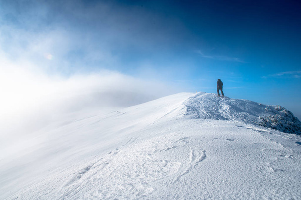 Hiker walking alone on the mountains edge. High Quality photo - Fotografie, Obrázek