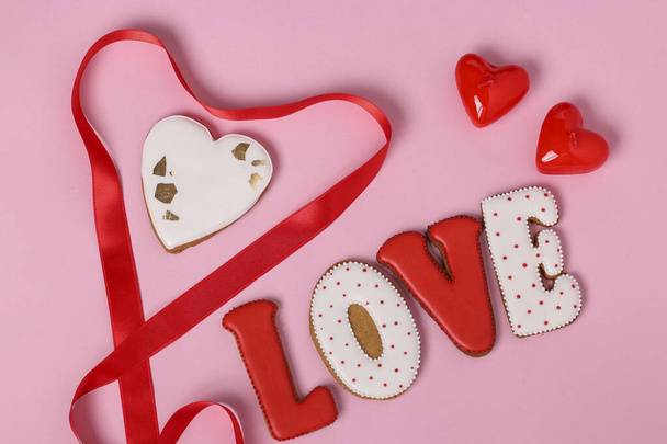 手作りのジンジャーブレッドと手紙ピンクの背景に位置するバレンタインデーへの愛、トップビュー - 写真・画像