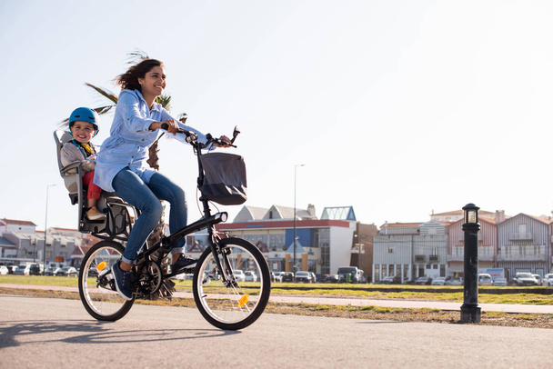 Moeder rijden op een fiets met jong kind  - Foto, afbeelding
