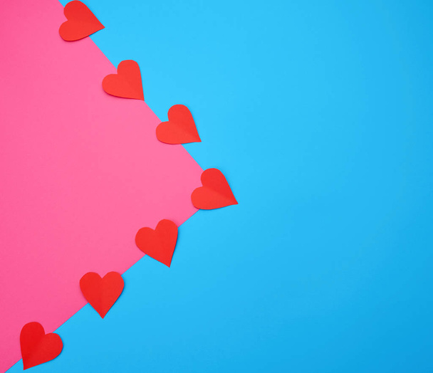 corazones cortados de papel rojo sobre un fondo rosa azul
 - Foto, imagen