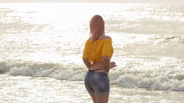 kaunis nainen vaaleanpunaiset hiukset auringonlaskun aikaan rannalla - Valokuva, kuva