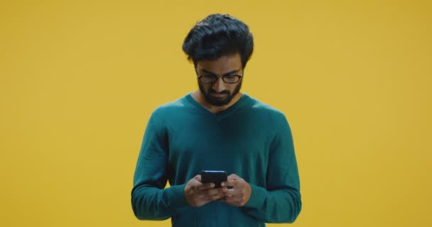 Young man texting on smartphone - Кадри, відео