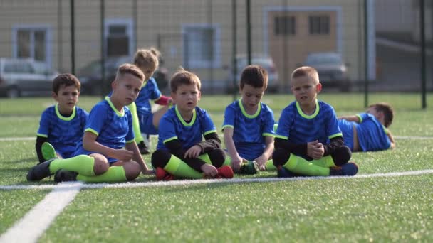 Tired soccer players relaxing during training - Footage, Video