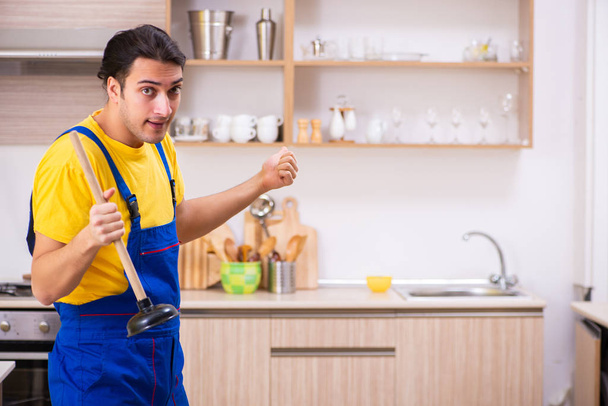 Jeune entrepreneur masculin réparer robinet à la maison - Photo, image