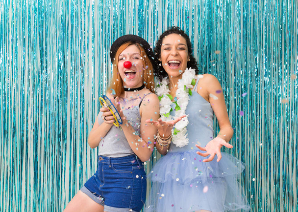 Двое друзей на карнавале. В клоунском носу и гавайском ожерелье. Преобладание цвета синий
.  - Фото, изображение
