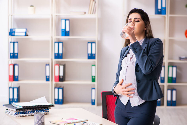 Fiatal terhes nő dolgozik az irodában - Fotó, kép