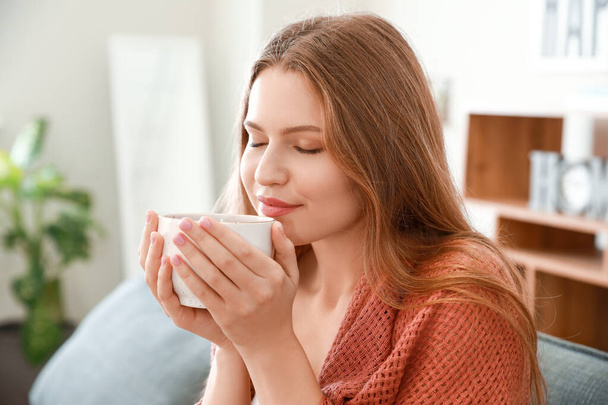 Счастливая женщина с чашкой чая отдыхает дома
 - Фото, изображение