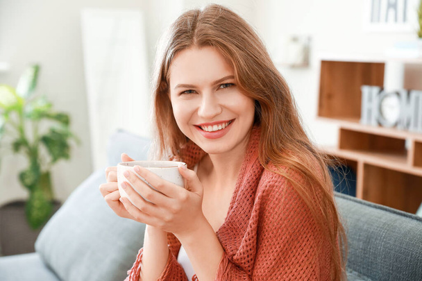 Mujer feliz con taza de té descansando en casa
 - Foto, Imagen