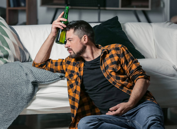 Mature man drinking beer at home. Concept of alcoholism - 写真・画像