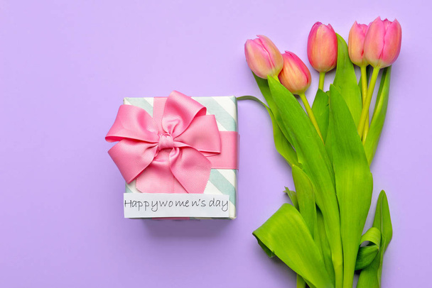 Flowers and gift for International Women's Day on color background - Photo, Image