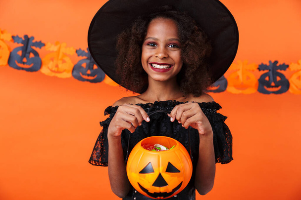 Image of happy african american girl holding toy pumpkin - Fotoğraf, Görsel