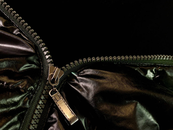 Background texture: zipper in a jacket on a black background. Opened lock on knit fabric. - Photo, Image