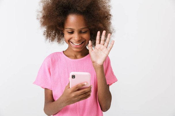 Happy young african girl kid using mobile phone. - Valokuva, kuva