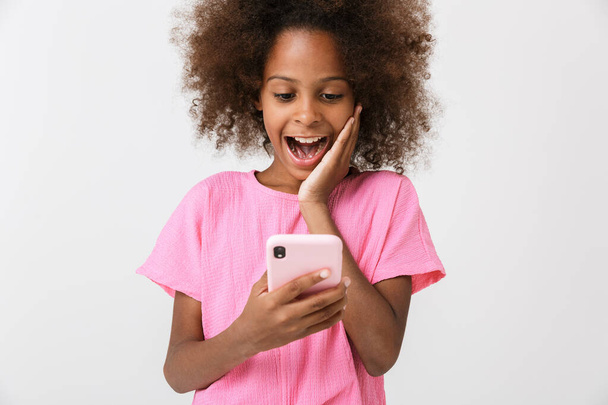 Happy young african girl kid using mobile phone. - 写真・画像