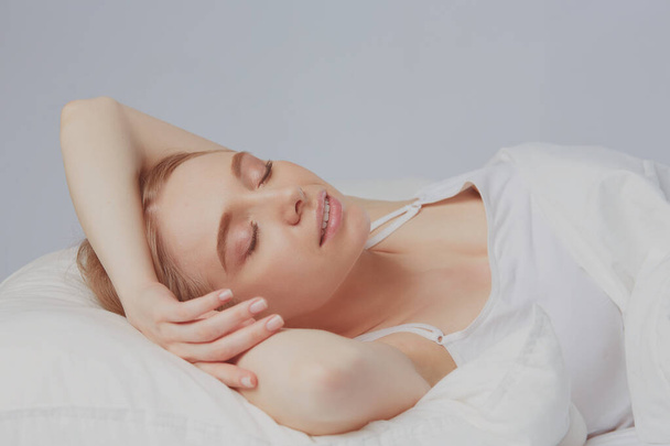 Photo of sleeping young woman lying in bed with eyes closed - Foto, Imagen