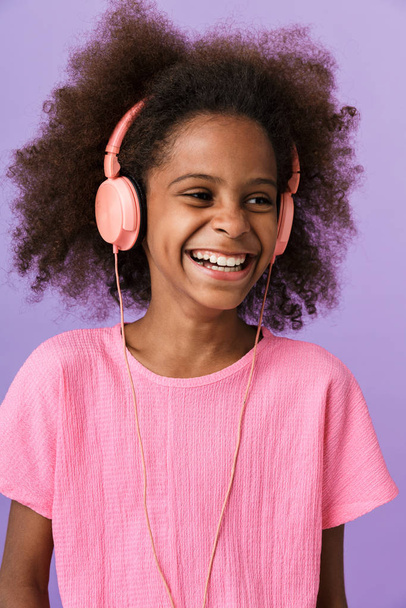 Happy young african girl kid with headphones. - Фото, изображение