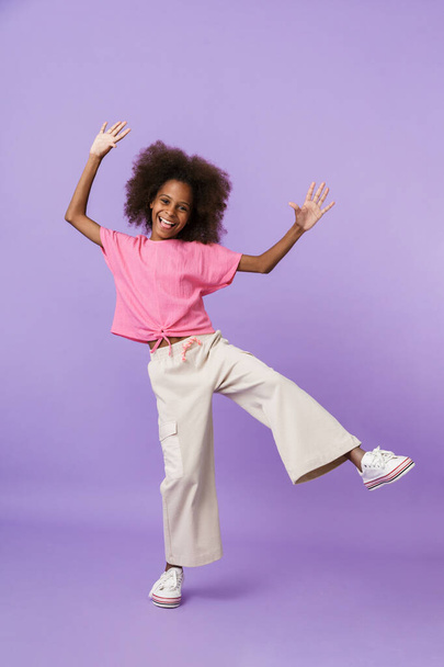 Pleased african girl kid posing isolated over purple wall - Photo, Image