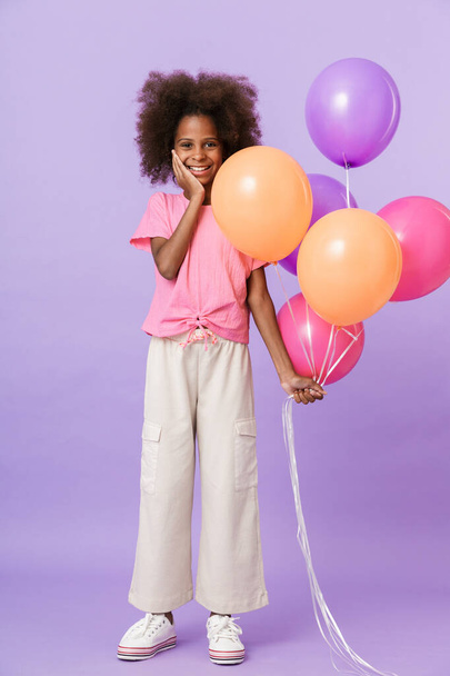 Pleased african girl kid with balloons. - 写真・画像
