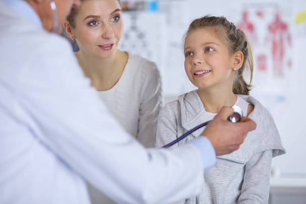 Girl and doctor with stethoscope listening to heartbeat - Foto, Imagem