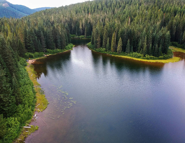 Stunning Olallie Lake with the forest reflecting in the pristine water surrounded by the gifford pinchot national forest hidden in the green mountains of southern Washington State in Skamania County - Foto, imagen