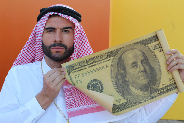 Uomo d'affari arabo che mostra un gigantesco biglietto da 100 dollari
 - Foto, immagini