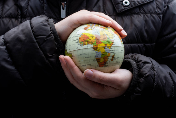 Homme tenant un modèle de globe terrestre dans ses mains
 - Photo, image