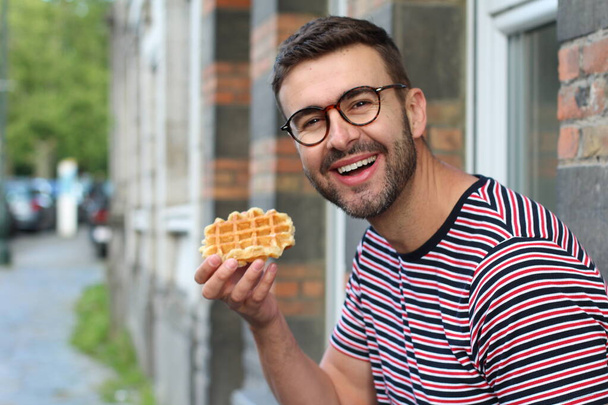 Leuke vent die een wafel eet in Brussel, België - Foto, afbeelding