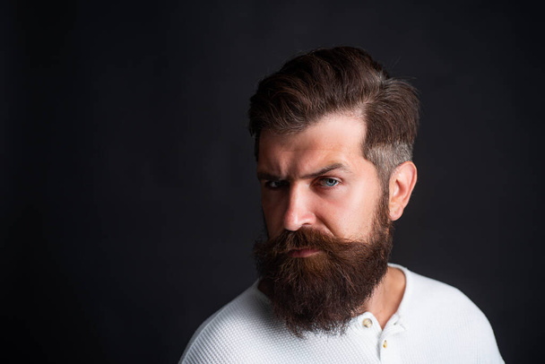 Portrait of adult man of Caucasian appearance isolated on black background. Close-up face of bearded man on black background - professional studio light. - Фото, изображение