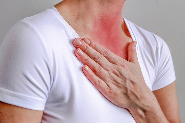 Halsschmerzen, rot dargestellt, mit der Hand gehalten, isoliert auf weißem Hintergrund. - Foto, Bild