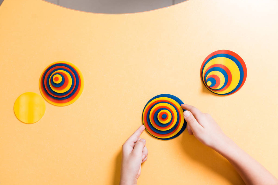 Visão superior da criança jogando colorido jogo educativo na mesa em classe montessori
 - Foto, Imagem