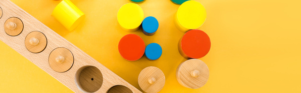 Bovenaanzicht van houten educatieve spelletjes op gele achtergrond, panoramisch schot - Foto, afbeelding