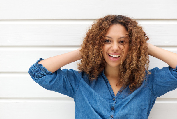 Retrato de uma jovem mulher feliz sorrindo com as mãos no cabelo
 - Foto, Imagem