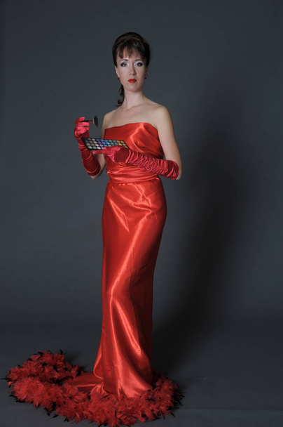 brunette in a long red dress on a gray background in the studio  - Φωτογραφία, εικόνα