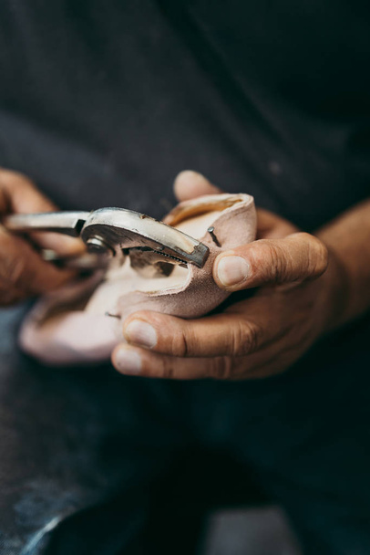 Close up shot of old shoemaker in his store. Traditional way of shoe making process. - Fotó, kép