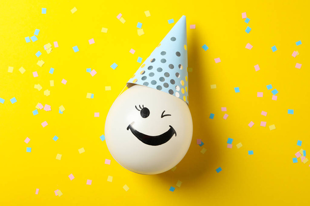 Ballon avec visage heureux sur fond jaune décoré, vue de dessus
 - Photo, image