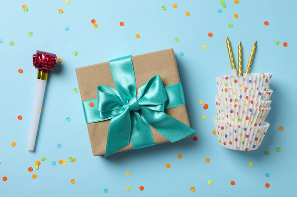 Coffret cadeau avec arc et accessoires d'anniversaire sur fond bleu, t
 - Photo, image