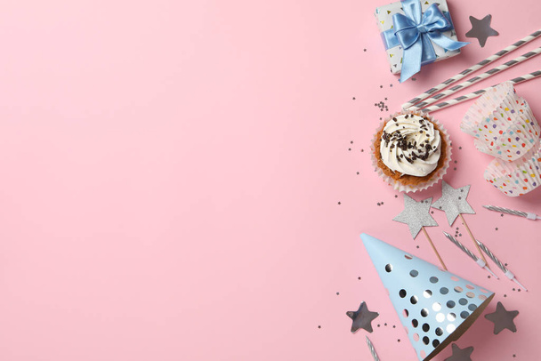 Композиція з кексом та аксесуарами до дня народження на рожевому фоні
 - Фото, зображення
