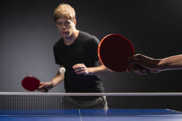 Tischtennis-Tischtennispaddeln und weißer Ball auf blauem Brett - Foto, Bild