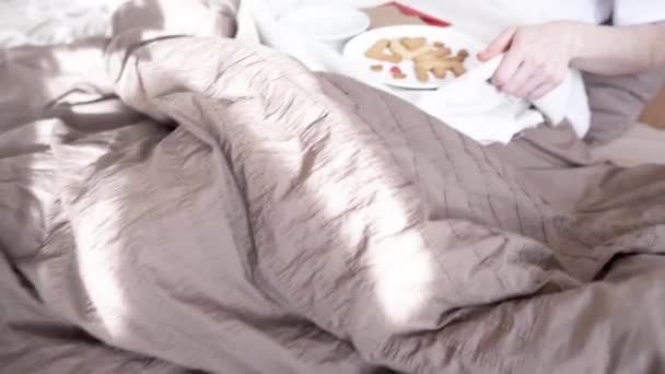 Woman have a romantic Breakfast in cozy morning bed. Coffee and word love from cookies. Surprise on Valentines day - Video