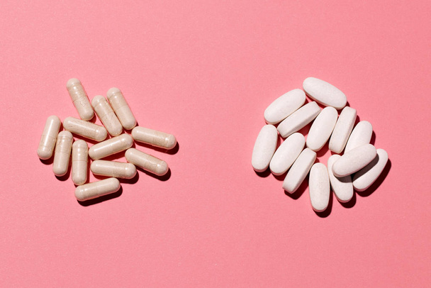 Дві купи ліків ізольовані на рожевому плоскому студійному дробі
. - Фото, зображення