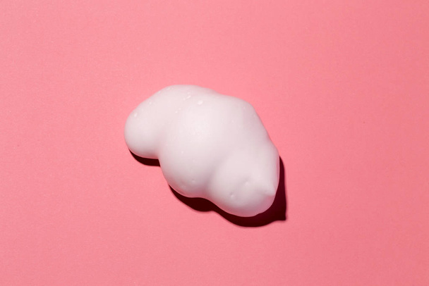 Hair foam piece on pink paper background. - Foto, Bild