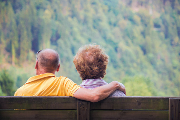 lovely couple sitting on bench, back view of middle aged lovers - 写真・画像