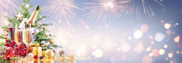 Πρωτοχρονιά με σαμπάνια και πυροτεχνήματα - Χρυσά φώτα σε μπλε φόντο  - Φωτογραφία, εικόνα
